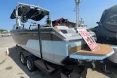 Slide: The Image of 2024 Nautique GS24 boat on trailer, displayed outdoors. - 15