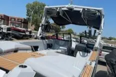 Slide: The Image of 2024 Nautique GS24 boat with spacious seating and modern design in a marina setting. - 6