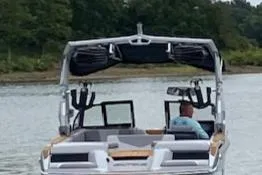 Slide: The Image of 2024 Nautique GS24 boat on a lake with a person at the helm. - 7