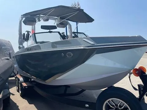 Slide: The Image of 2024 Nautique GS24 boat on trailer, sleek design, sunny day. - 8