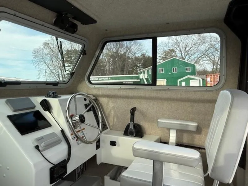 Slide: The Image of Interior of 2025 Parker 2120 Sport Cabin boat with steering wheel and seating. - 10