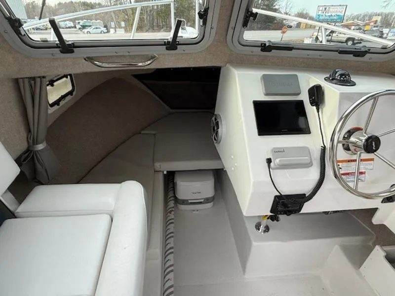 Slide: The Image of 2025 Parker 2120 Sport Cabin interior with steering wheel, seating, and navigation equipment. - 11