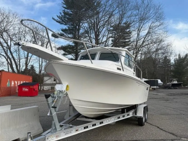 Slide: The Image of 2025 Parker 2120 Sport Cabin boat on trailer, parked outdoors. - 4