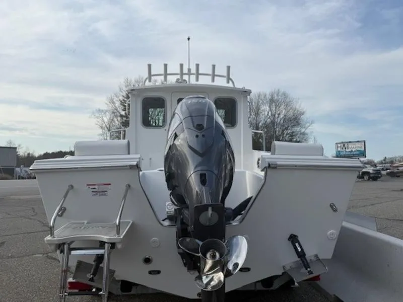 Slide: The Image of 2025 Parker 2120 Sport Cabin boat, rear view with outboard motor, parked outdoors. - 5