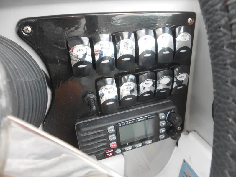Slide: The Image of Control panel of a 2004 Formula 37 PC boat with switches and a radio. - 16