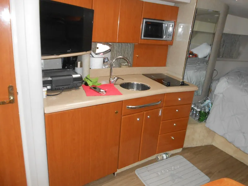 Slide: The Image of 2004 Formula 37 PC yacht interior with kitchenette, featuring wood cabinets, sink, and appliances. - 4