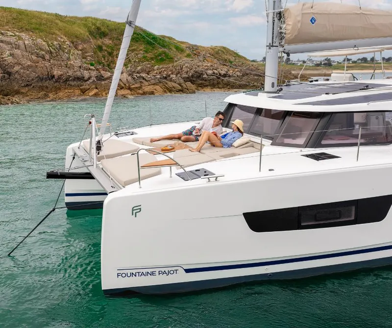 Slide: The Image of Couple relaxing on 2025 Fountaine Pajot NEW 41 catamaran in scenic coastal waters. - 41