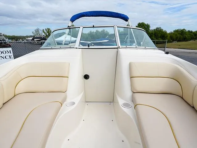 Slide: The Image of 2001 Sea Ray 190 Sundeck boat interior with beige seating and blue canopy. - 10
