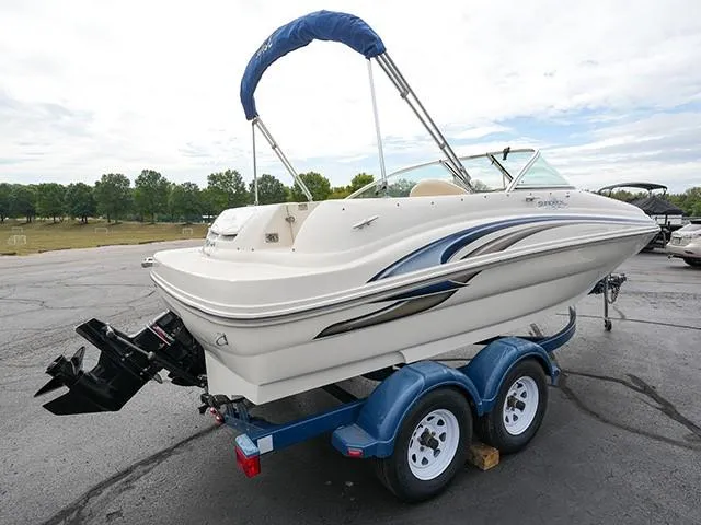 Slide: The Image of 2001 Sea Ray 190 Sundeck boat on trailer, parked outdoors with trees in background. - 4