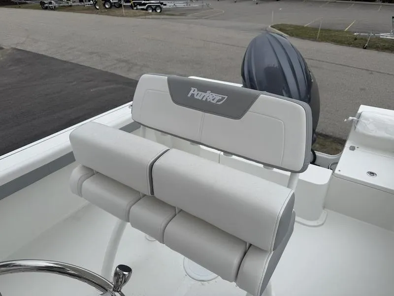 Slide: The Image of 2025 Parker 21 SE CC boat with cushioned seating and outboard motor. - 9