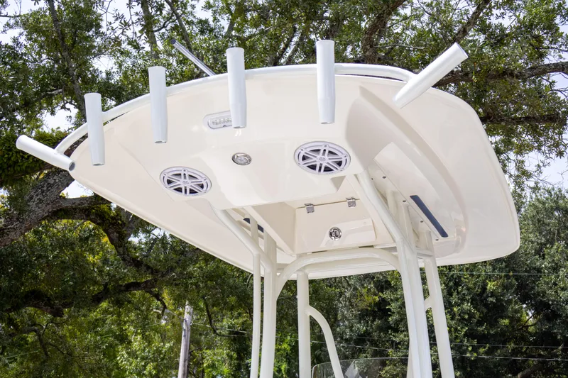 Slide: The Image of 2025 Pathfinder 2200 TRS boat T-top with rod holders and speakers, set against a leafy background. - 10