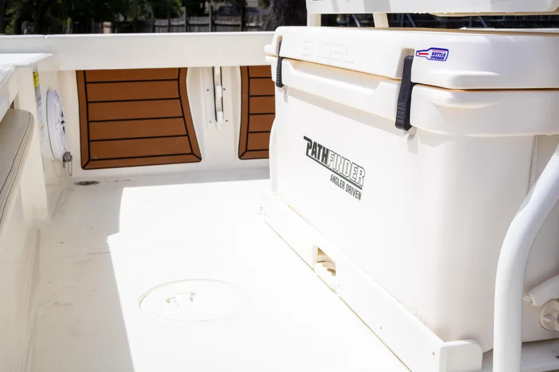 Slide: The Image of 2025 Pathfinder 2200 TRS boat deck with cooler and wood accents. - 11