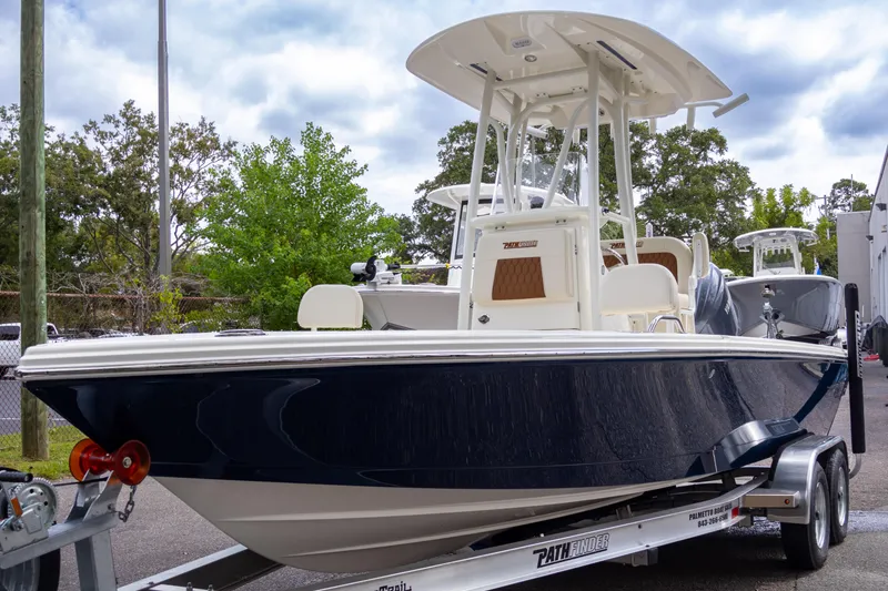 Slide: The Image of 2025 Pathfinder 2200 TRS boat on trailer, parked outdoors. - 2