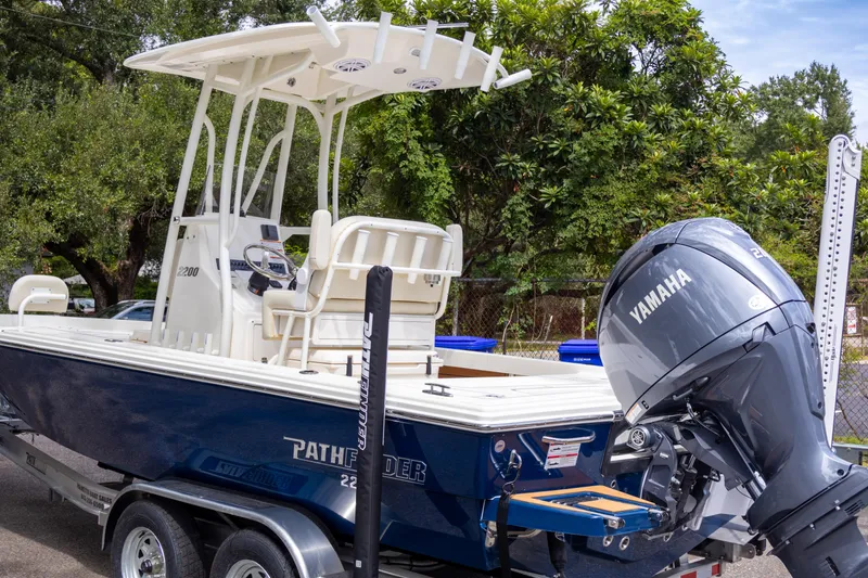 Slide: The Image of 2025 Pathfinder 2200 TRS boat with Yamaha engine on trailer, parked outdoors. - 4