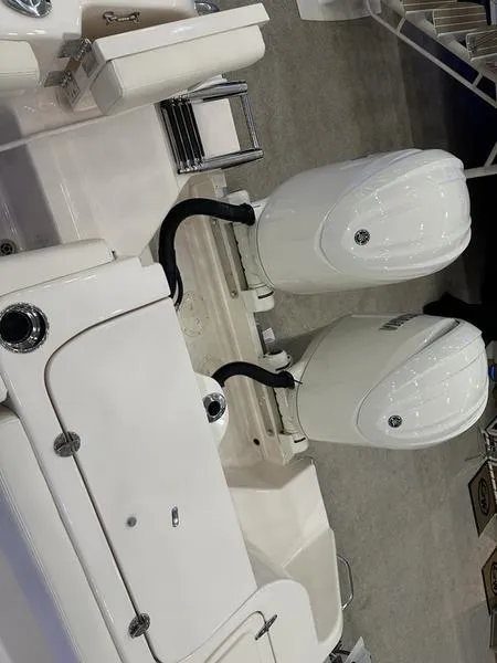 Slide: The Image of 2025 Grady-White Freedom 275 boat with dual outboard engines, showcased indoors. - 4