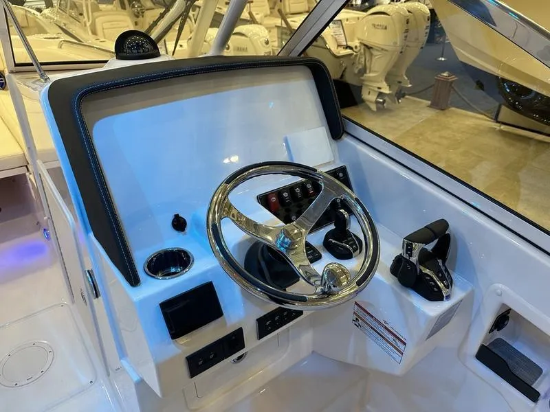 Slide: The Image of 2025 Grady-White Freedom 275 boat helm with steering wheel and controls. - 9