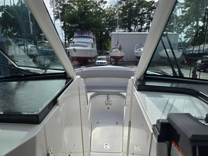 Slide: The Image of 2025 Pursuit DC 306 Dual Console boat interior at marina, surrounded by other boats. - 16