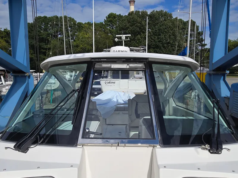 Slide: The Image of 2025 Pursuit DC 306 Dual Console boat docked, featuring sleek windshield design. - 17