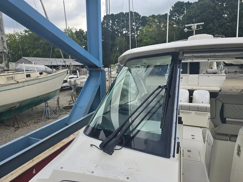 Slide: The Image of 2025 Pursuit DC 306 Dual Console boat in a marina setting. - 18