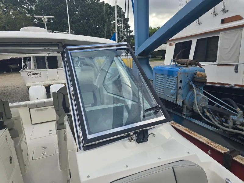 Slide: The Image of 2025 Pursuit DC 306 Dual Console boat in marina setting. - 19