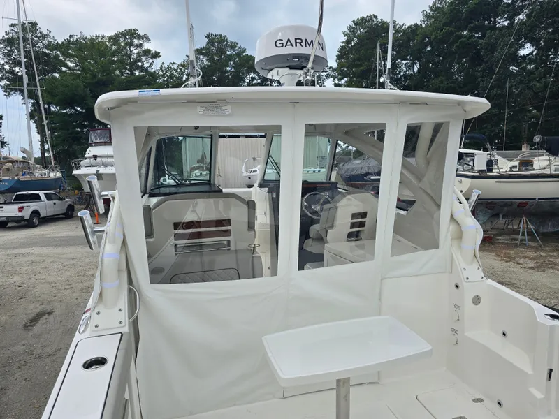 Slide: The Image of 2025 Pursuit DC 306 Dual Console boat with Garmin radar, docked in a marina. - 2