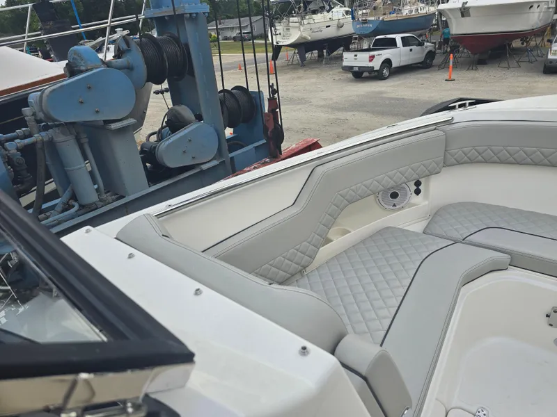 Slide: The Image of 2025 Pursuit DC 306 Dual Console boat interior with quilted seating in a marina setting. - 21