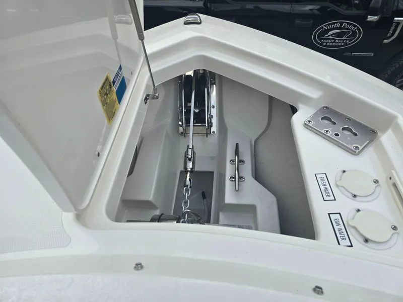 Slide: The Image of 2025 Pursuit DC 306 Dual Console anchor compartment with chain and storage features. - 23