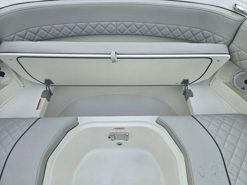 Slide: The Image of 2025 Pursuit DC 306 Dual Console boat with open storage compartment and quilted seating. - 24