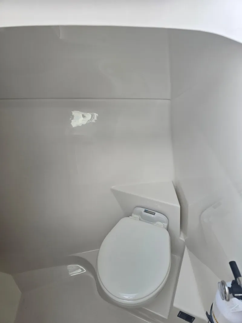 Slide: The Image of 2025 Pursuit DC 306 Dual Console boat interior with modern toilet. - 26