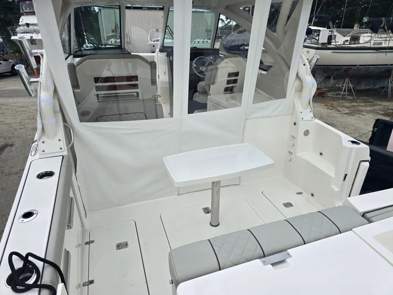 Slide: The Image of 2025 Pursuit DC 306 Dual Console boat interior with seating and table. - 3