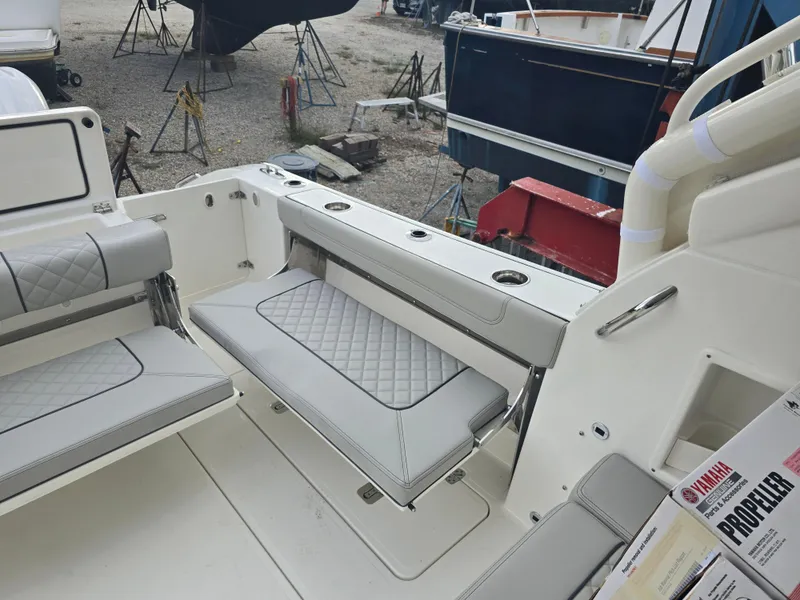 Slide: The Image of 2025 Pursuit DC 306 Dual Console boat interior with cushioned seating and storage. - 7