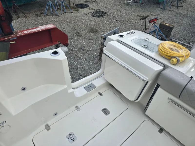 Slide: The Image of 2025 Pursuit DC 306 Dual Console boat deck with storage and hose. - 8