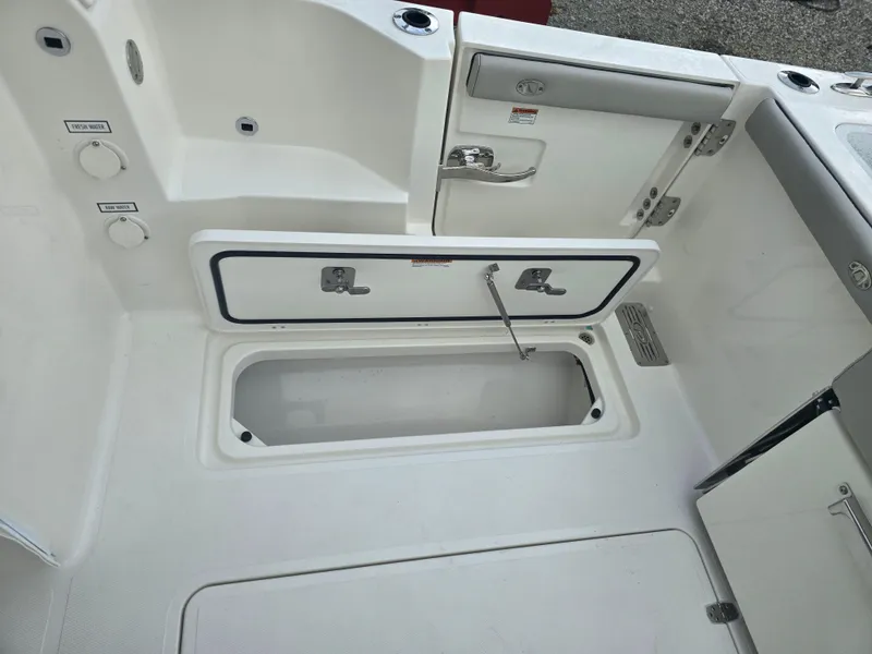 Slide: The Image of 2025 Pursuit DC 306 Dual Console boat interior with open storage compartment. - 9