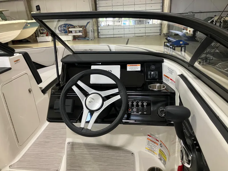 Slide: The Image of 2025 Sea Ray SPX 190 Outboard boat dashboard with steering wheel and controls in a showroom. - 10