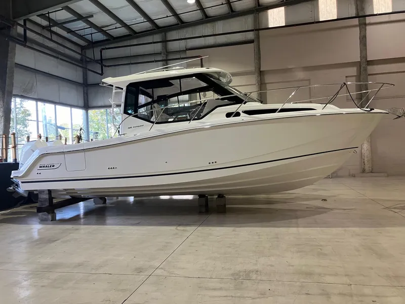 The Image of 2025 Boston Whaler 325 Conquest boat in a spacious indoor facility. - 0