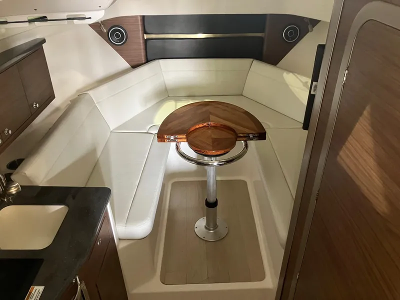 Slide: The Image of 2025 Boston Whaler 325 Conquest cabin interior with seating and wooden table. - 18