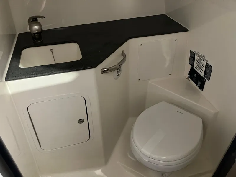 Slide: The Image of 2025 Boston Whaler 325 Conquest bathroom with sink and toilet, featuring modern design. - 23