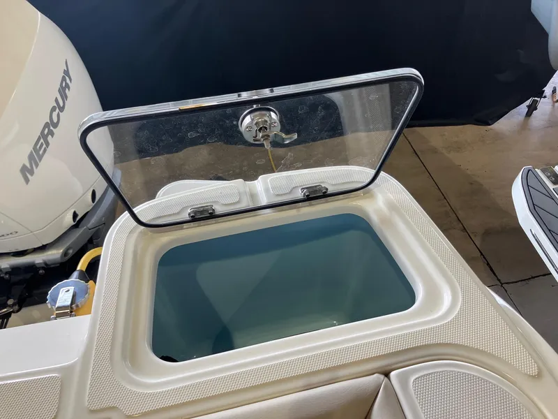 Slide: The Image of Open storage compartment on 2025 Boston Whaler 325 Conquest boat, with Mercury engine visible. - 8