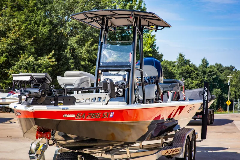The Image of Avid 23 Magnum 2022 fishing boat on trailer, parked outdoors. - 1