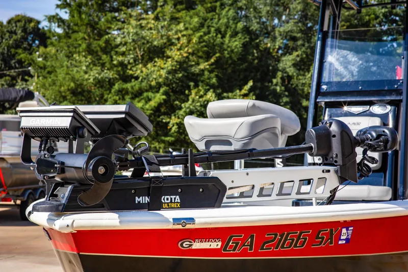 Slide: The Image of 2022 Avid 23 Magnum boat with Minn Kota Ultrex motor, red and white design. - 2