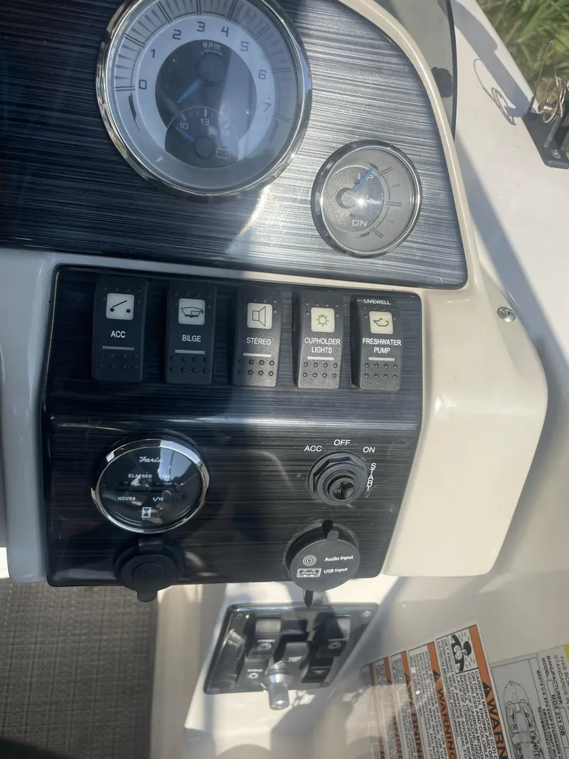 Slide: The Image of 2017 Starcraft MDX 211 O/B boat dashboard with control switches and gauges. - 5