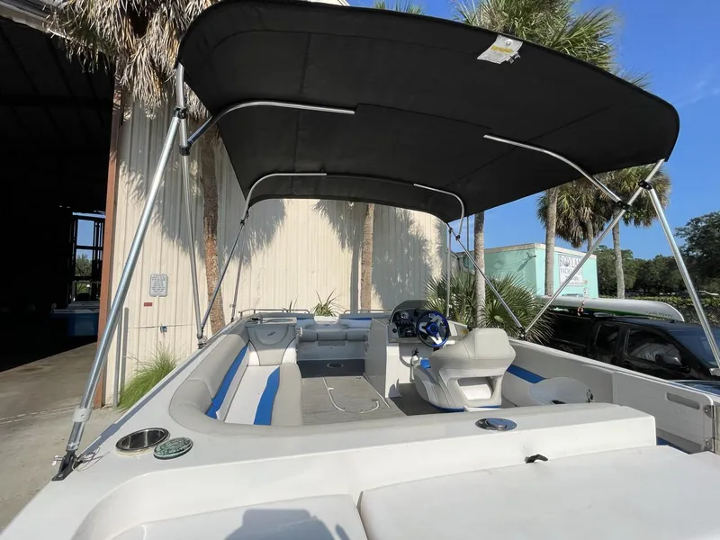 Slide: The Image of 2017 Starcraft MDX 211 O/B boat with canopy, docked near palm trees. - 6