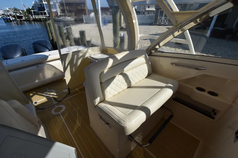 Slide: The Image of 2019 Grady-White Freedom 325 boat interior with beige seating and waterfront view. - 15