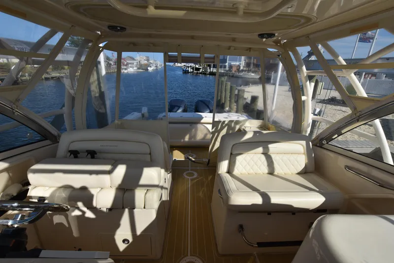 Slide: The Image of Interior view of 2019 Grady-White Freedom 325 boat with luxurious seating and waterfront backdrop. - 18