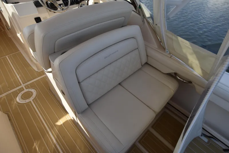 Slide: The Image of 2019 Grady-White Freedom 325 boat interior with beige seating and wood flooring. - 19