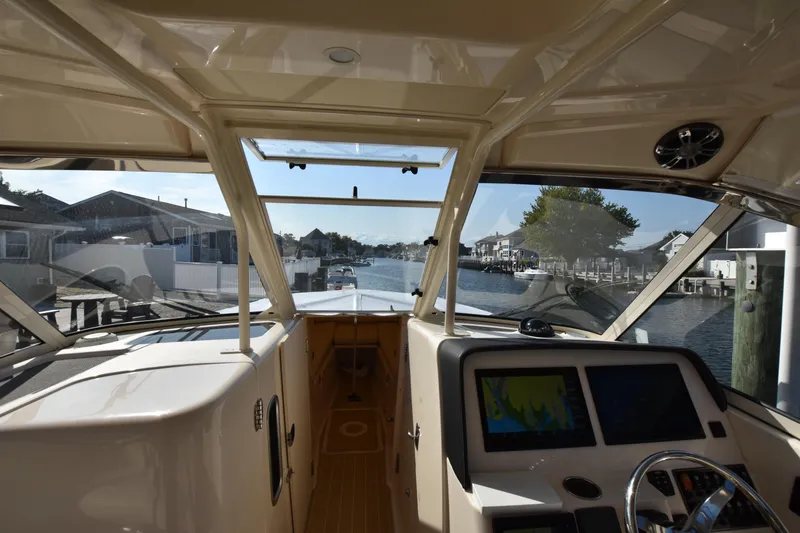 Slide: The Image of Interior view of 2019 Grady-White Freedom 325 boat, featuring navigation screens and waterfront scenery. - 23