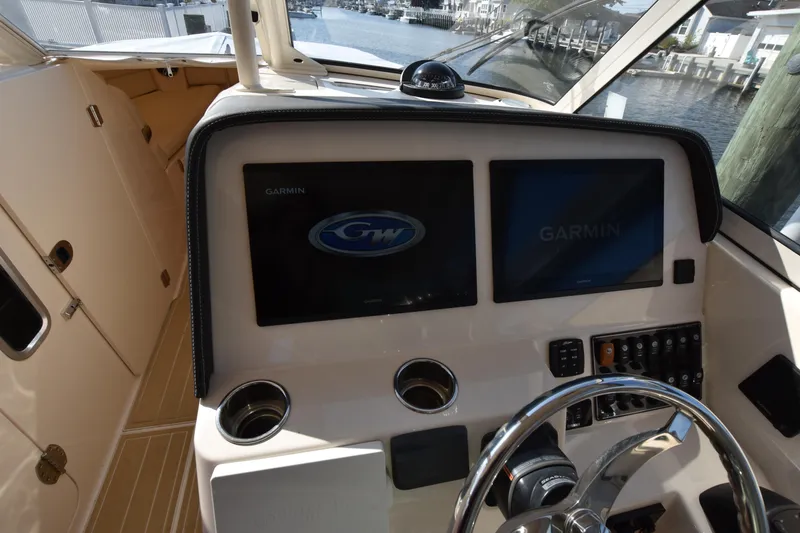Slide: The Image of 2019 Grady-White Freedom 325 boat dashboard with Garmin displays and steering wheel. - 25