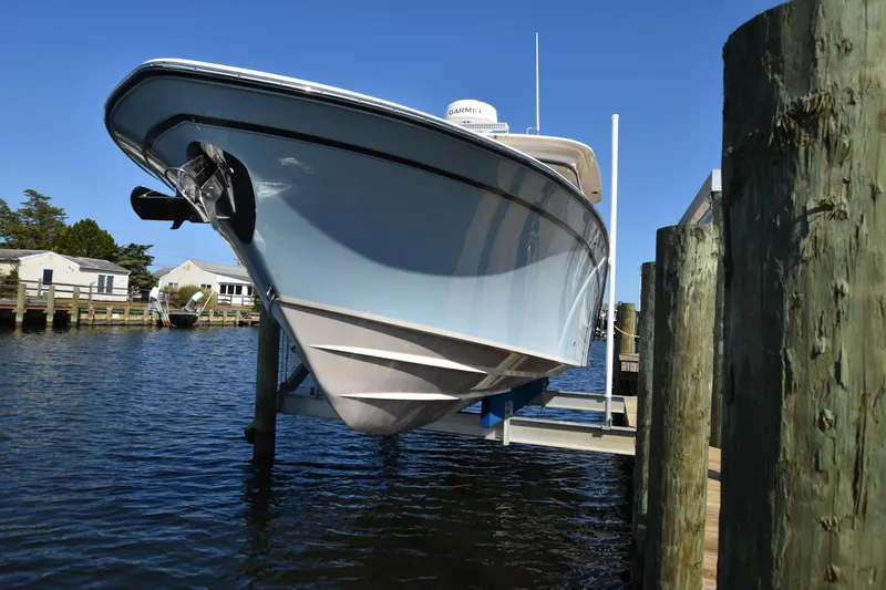 Slide: The Image of 2019 Grady-White Freedom 325 boat docked on a lift in a marina. - 3