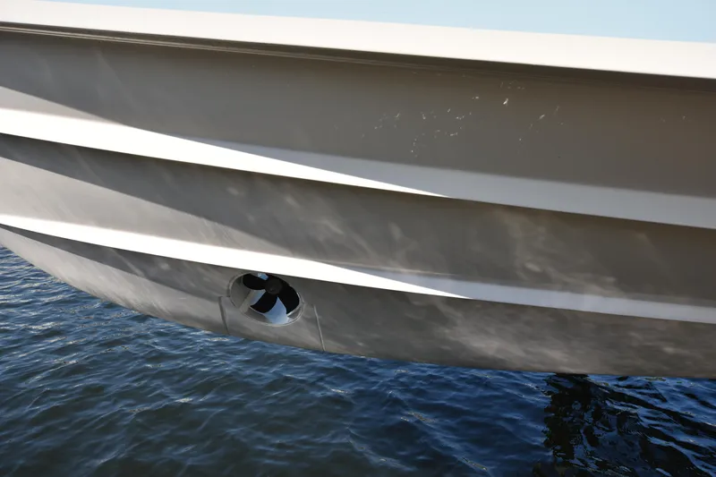 Slide: The Image of 2019 Grady-White Freedom 325 boat hull on water, close-up view. - 46