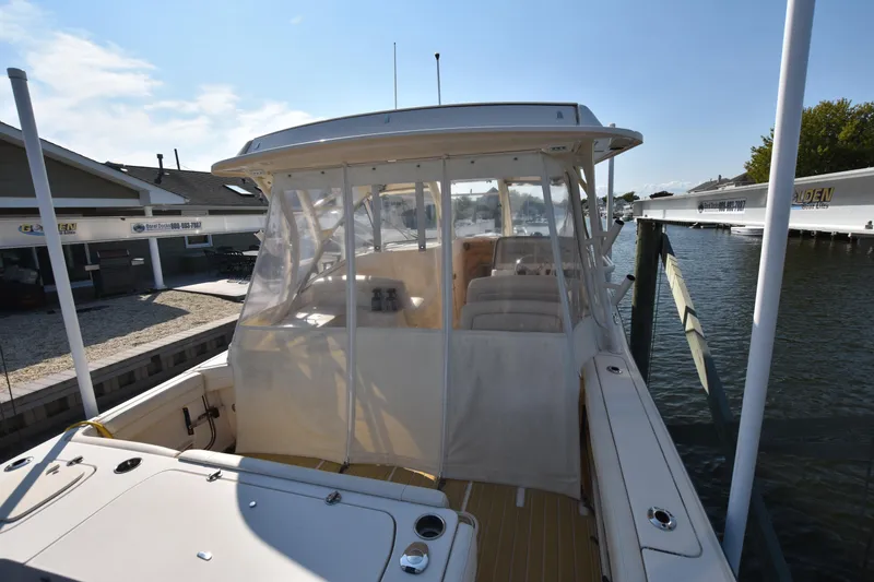 Slide: The Image of 2019 Grady-White Freedom 325 boat docked, featuring enclosed cabin and spacious deck. - 8